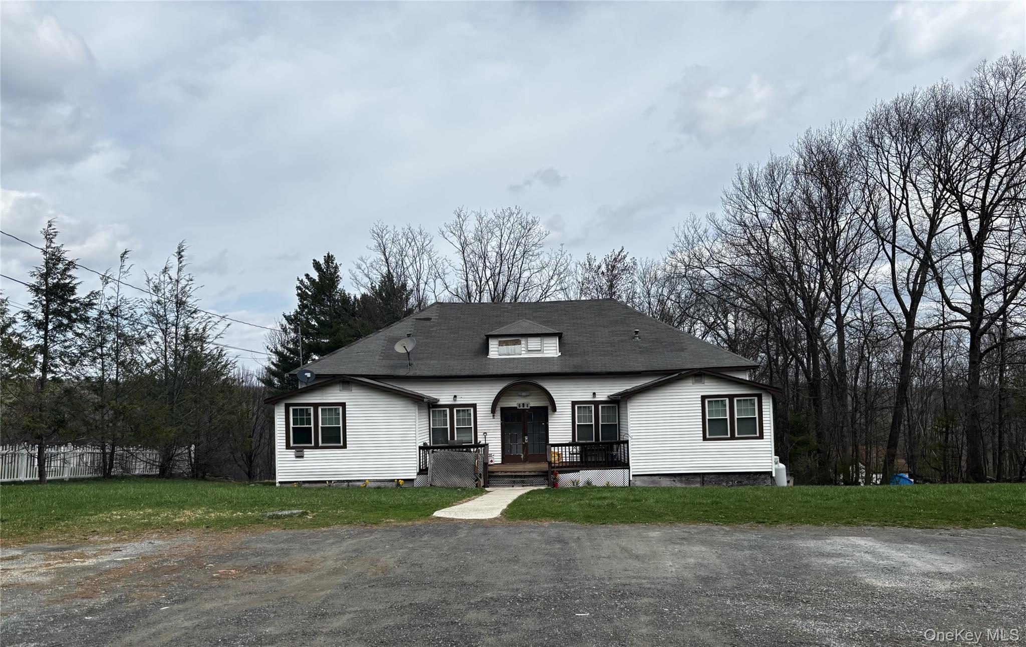 a front view of a house with a yard and trees