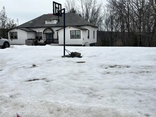 a front view of a house with a yard covered in snow