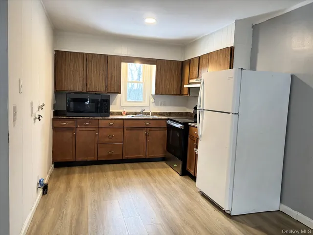 a kitchen with a refrigerator a sink and cabinets