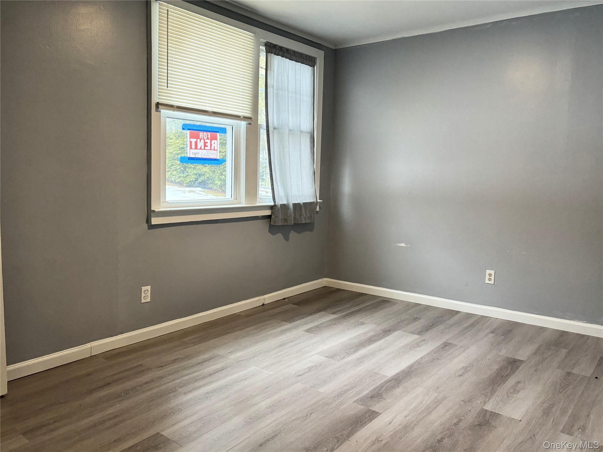 210 Mt Prosper Road Wurtsboro, NY 12790 - Photo 10 of 14 a view of an empty room with wooden floor and a window