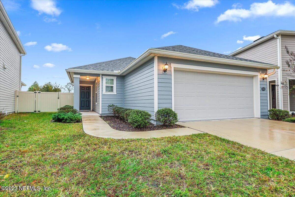 a front view of house with yard and garage