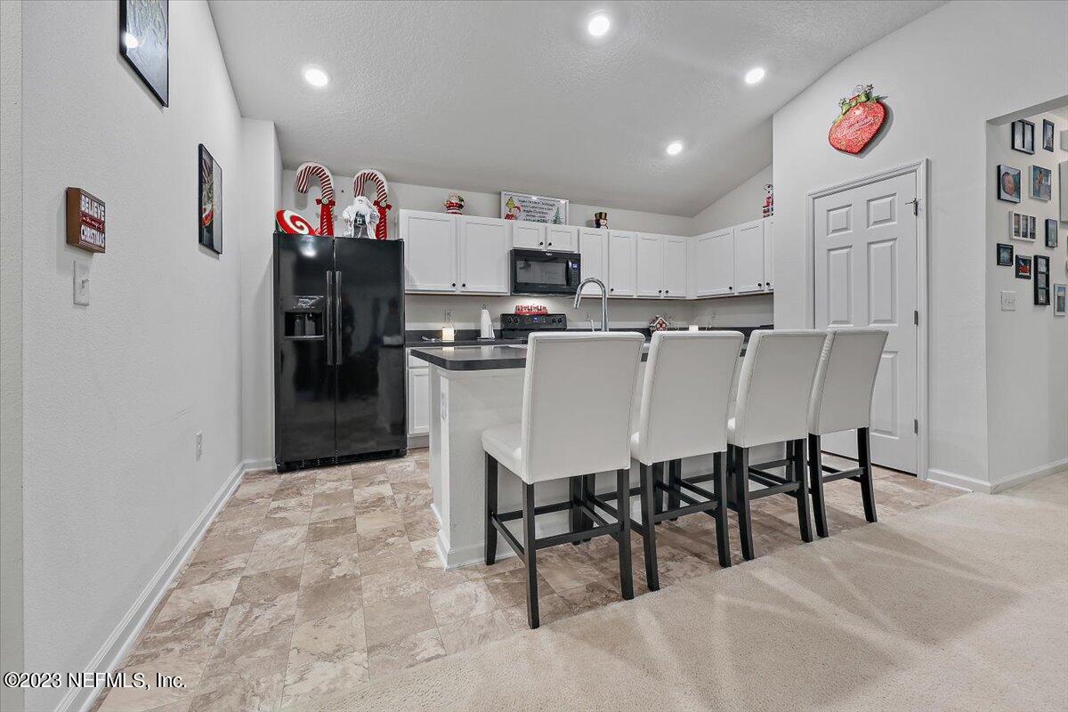 8300 Guild Way Jacksonville, FL 32222 - Photo 7 of 18 a kitchen with stainless steel appliances kitchen island granite countertop a refrigerator and microwave