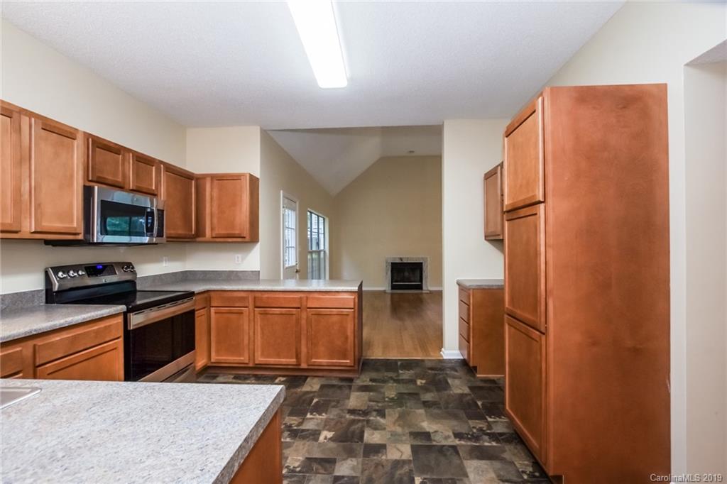 7329 Reedy Creek Road Charlotte, NC 28215 - Photo 14 of 25 a kitchen with stainless steel appliances granite countertop a refrigerator stove microwave and sink