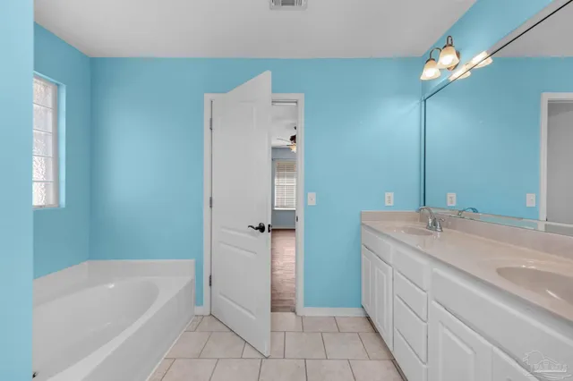 a bathroom with a tub sink and a mirror