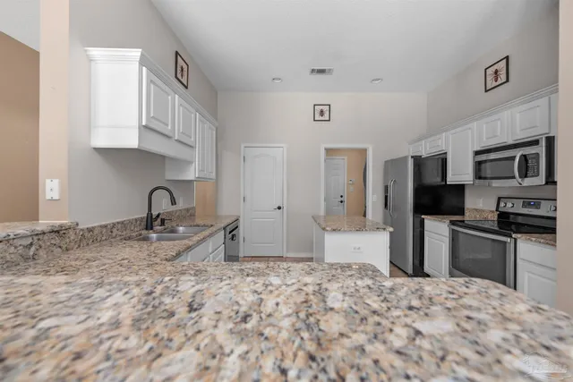 a kitchen with stainless steel appliances granite countertop a sink and cabinets
