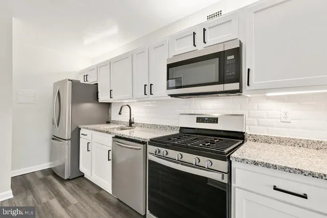 a kitchen with stainless steel appliances granite countertop a stove microwave sink and refrigerator