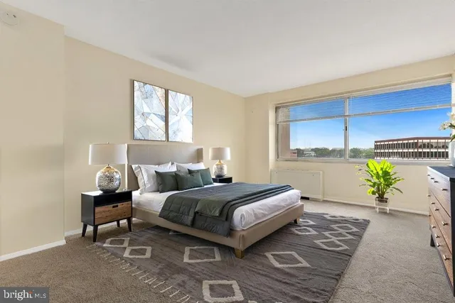 a bedroom with a bed lamp and a potted plant