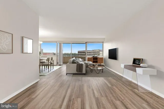 a large living room with furniture a flat screen tv and a wooden floor