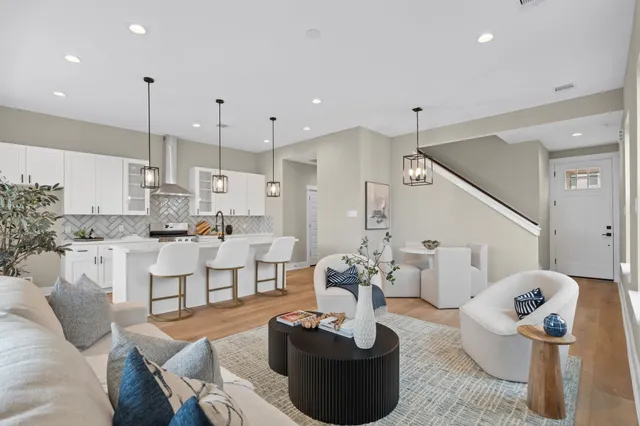 a living room with furniture kitchen and a chandelier