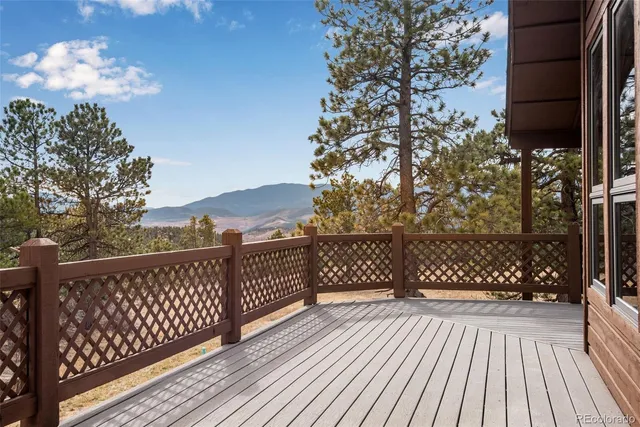 a view of a balcony with wooden floor and fence