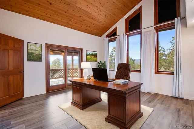 a view of a workspace with furniture and a window