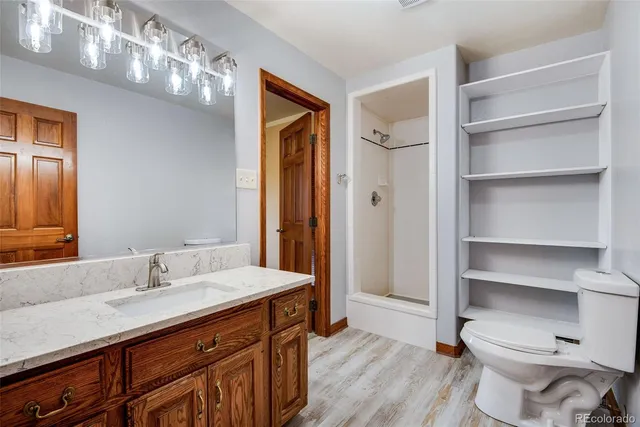 a bathroom with a sink a toilet and shower