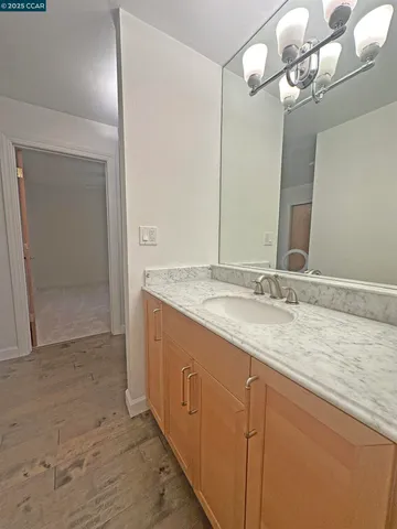 a bathroom with a granite countertop sink and a mirror