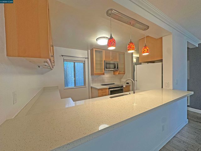 a kitchen with stainless steel appliances granite countertop a sink and a refrigerator