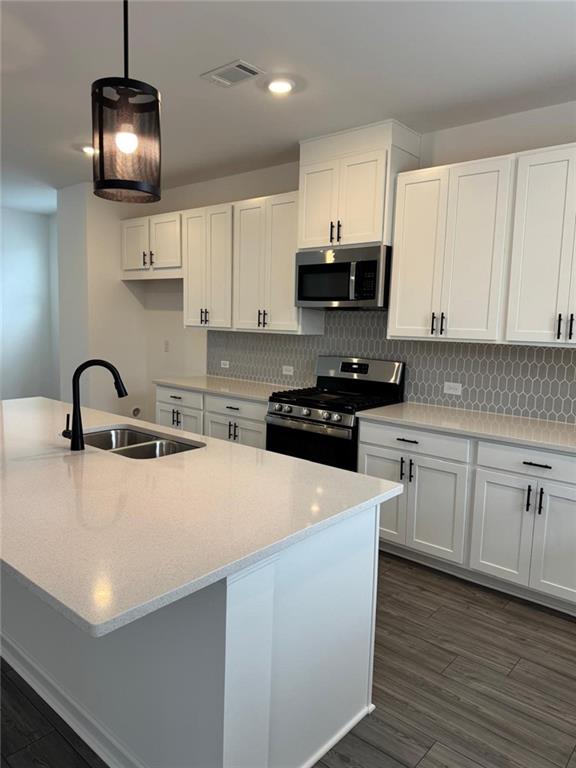 1 Peeples Drive Lawrenceville, GA 30046 - Photo 4 of 11 a kitchen with stainless steel appliances a stove a sink a microwave and cabinets