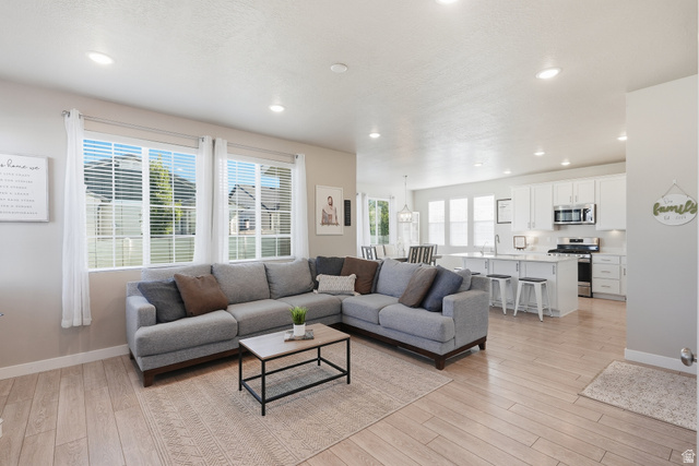 3244 West 1670th Street North Provo, UT 84601 - Photo 8 of 56 Open-concept living area with wood-finish flooring, recessed lighting, and multiple large windows