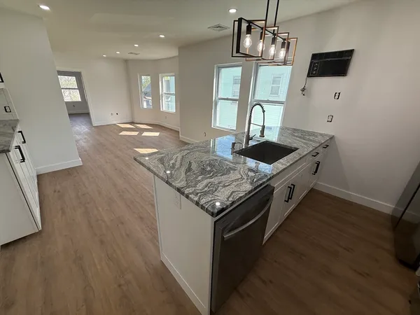 a kitchen with stainless steel appliances granite countertop a sink stove and refrigerator