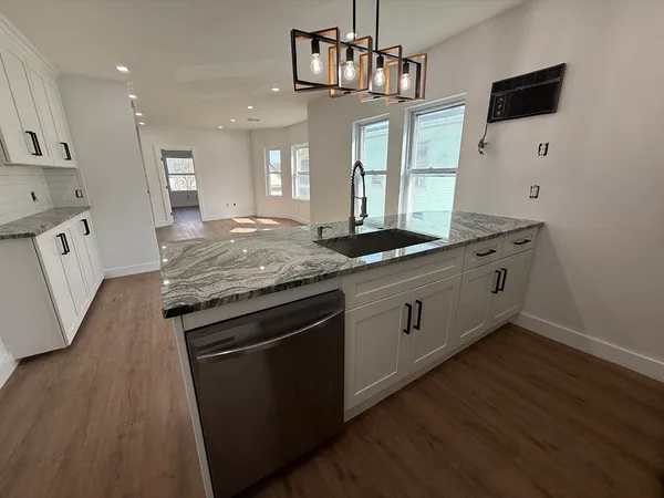 a kitchen with stainless steel appliances granite countertop a sink stove and wooden floor