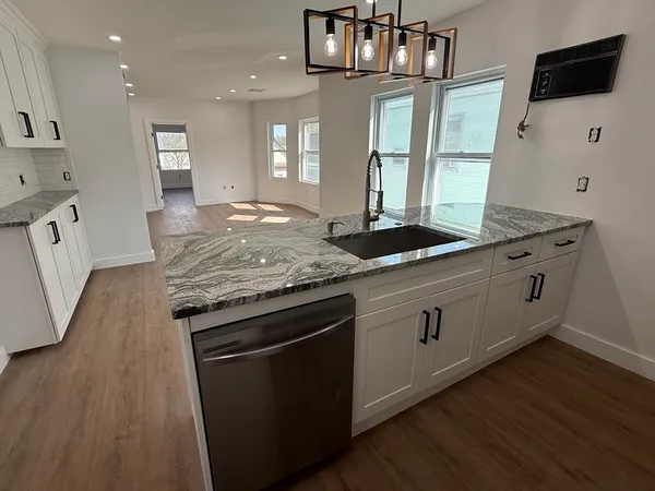 a kitchen with granite countertop a stove and cabinets