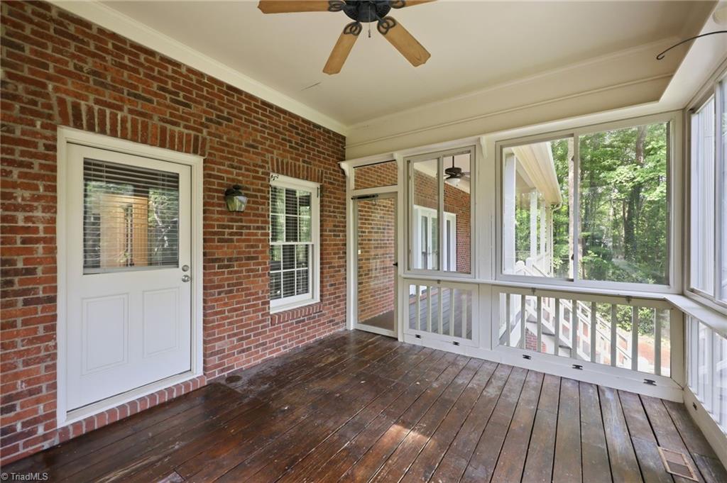 8861 Boylston Road Colfax, NC 27235 - Photo 36 of 50 Covered screened porch extends the living space outdoors—perfect for morning coffee, evening relaxation, or enjoying the peaceful wooded surroundings.