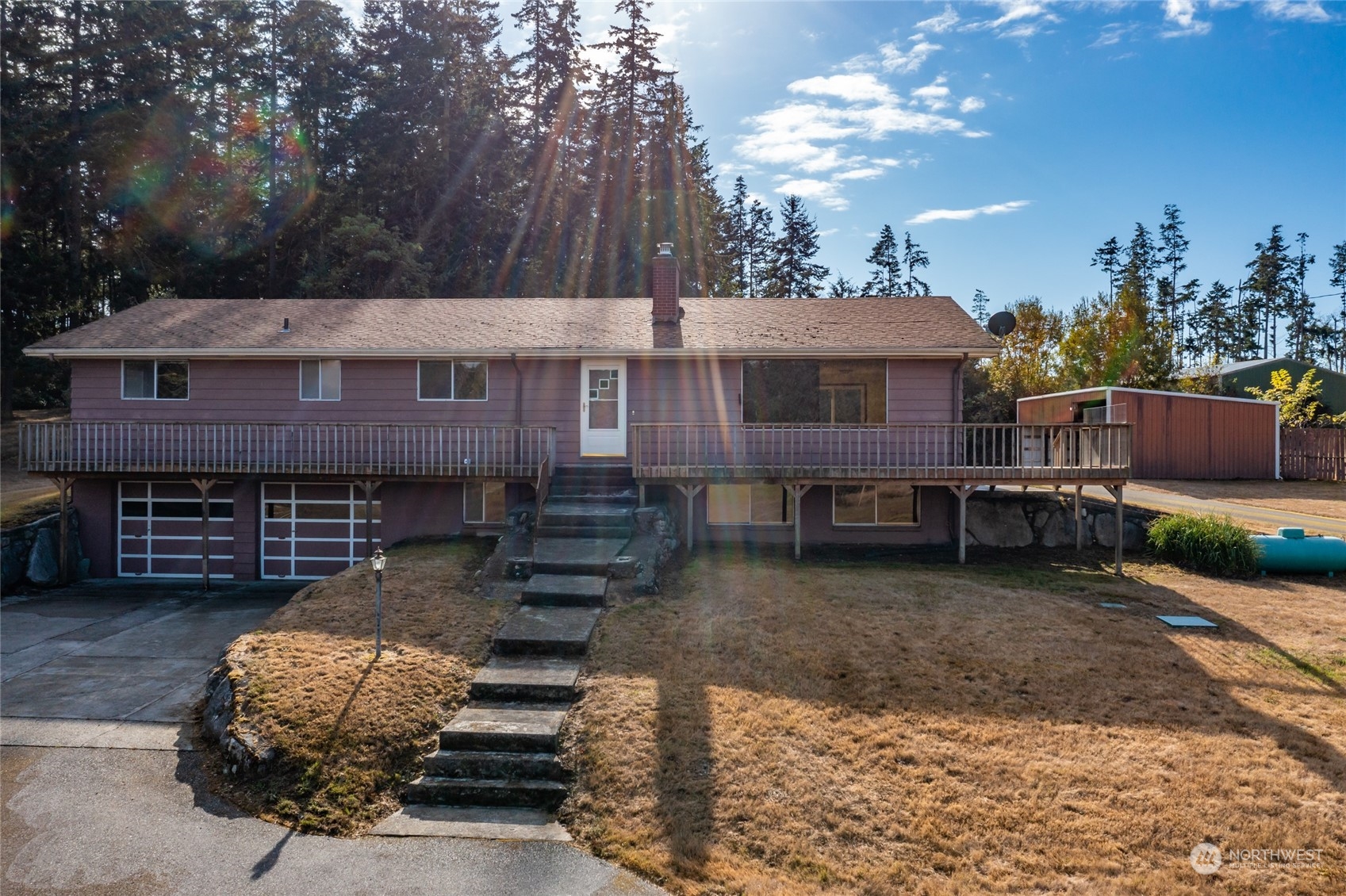 a view of a house with a yard and a large tree