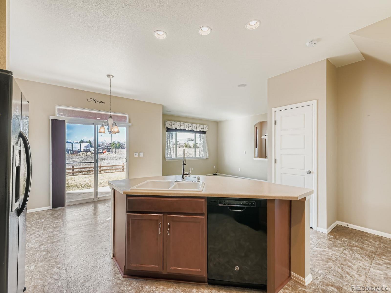 8645 Raspberry Drive Frederick, CO 80504 - Photo 13 of 29 a kitchen with kitchen island a sink stainless steel appliances and window