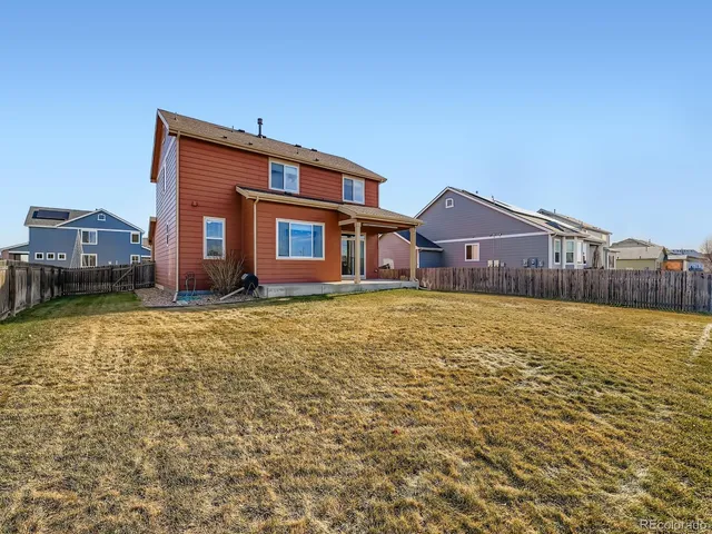 a front view of house with yard and trees in the background