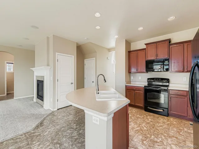 a kitchen with stainless steel appliances granite countertop a refrigerator a sink and a stove