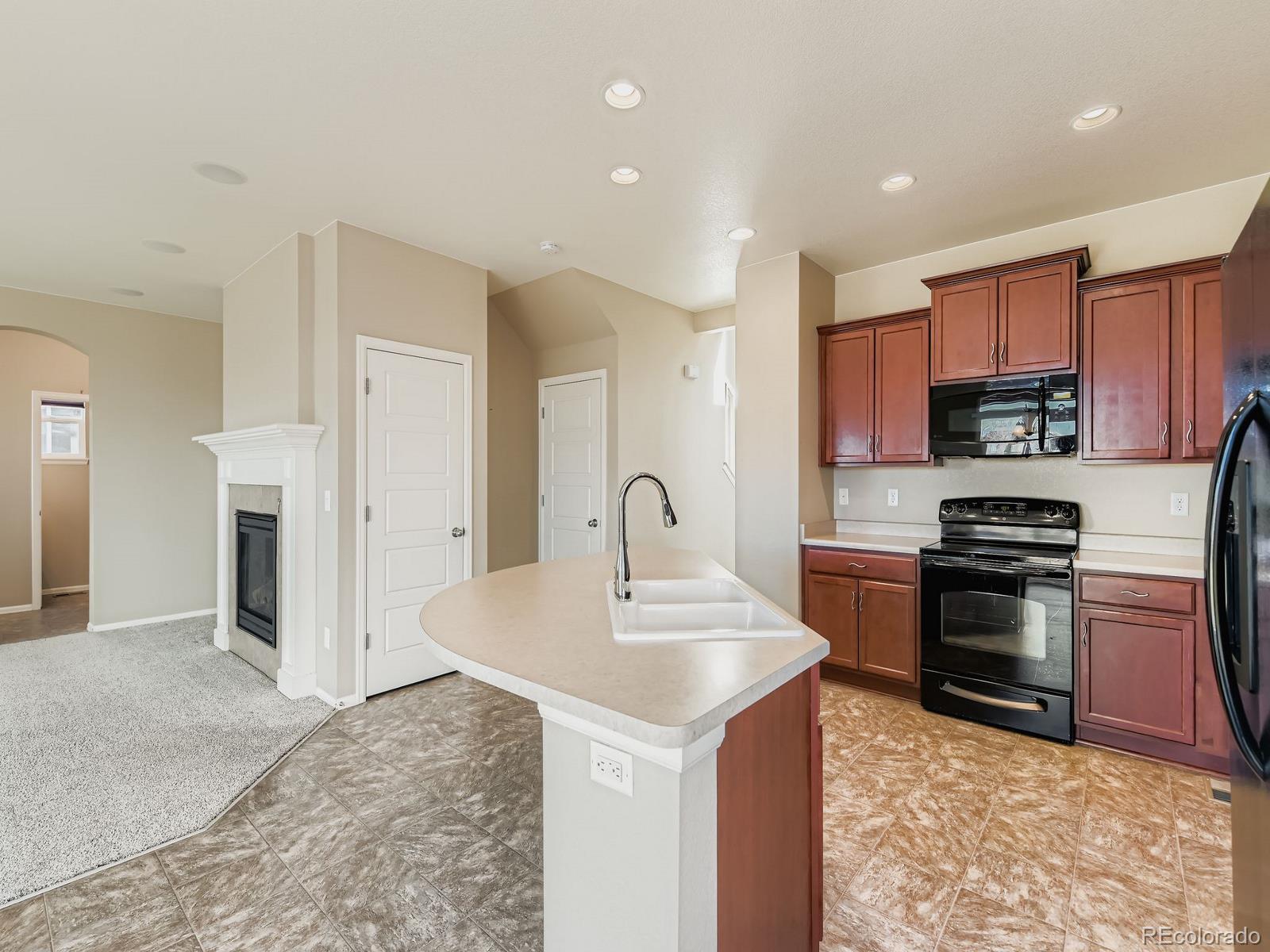 8645 Raspberry Drive Frederick, CO 80504 - Photo 10 of 29 a kitchen with stainless steel appliances granite countertop a sink stove and refrigerator