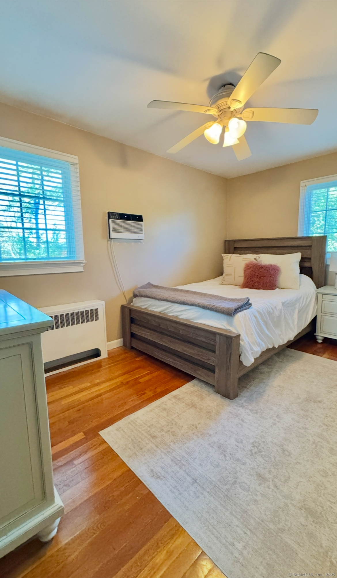 357 Harvester Road Fairfield, CT 06825 - Photo 7 of 10 a spacious bedroom with a bed and a chandelier