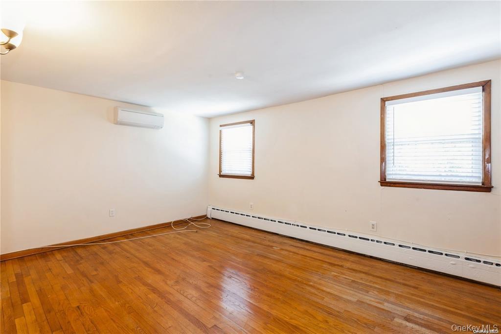 77 Duck Pond Road Glen Cove, NY 11542 - Photo 26 of 36 an empty room with wooden floor and windows