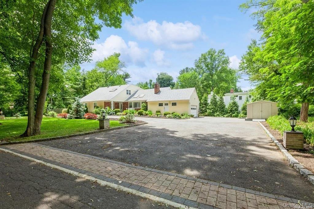 77 Duck Pond Road Glen Cove, NY 11542 - Photo 6 of 36 a white house with a yard and plants