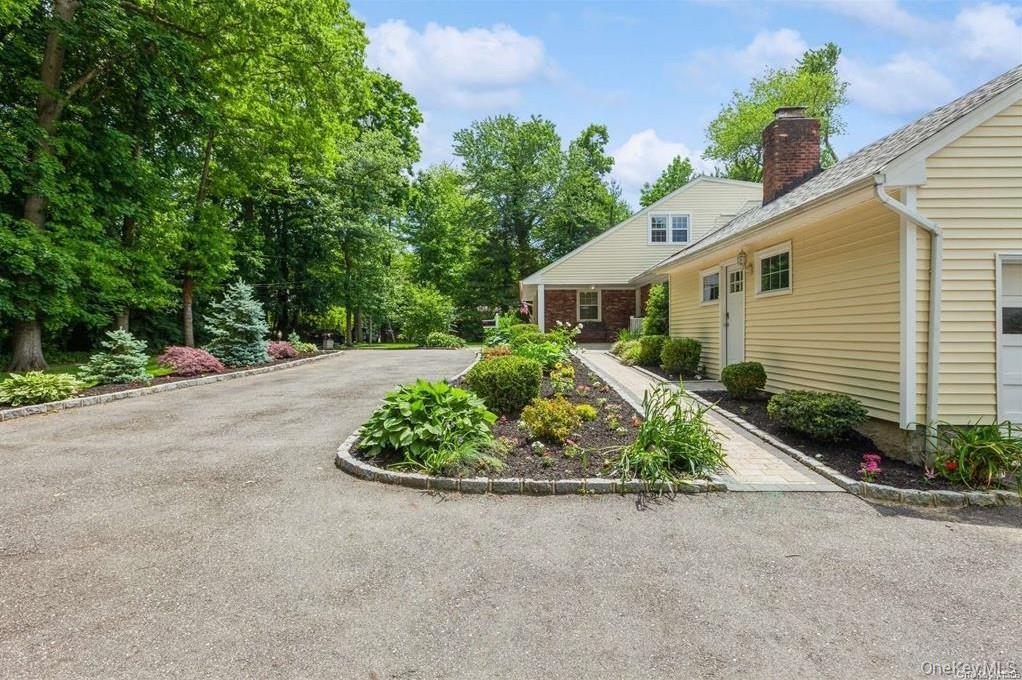 77 Duck Pond Road Glen Cove, NY 11542 - Photo 7 of 36 a front view of a house with a yard and outdoor seating