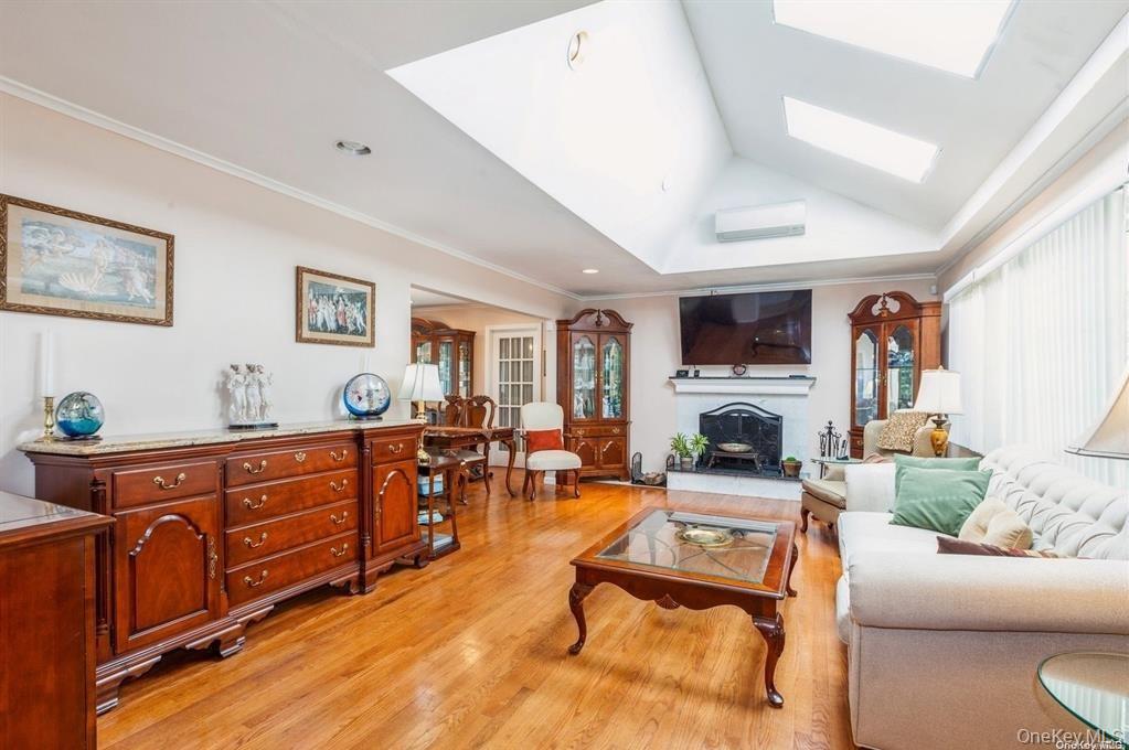 77 Duck Pond Road Glen Cove, NY 11542 - Photo 10 of 36 a living room with furniture a fireplace and a large window