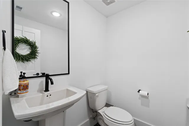 a bathroom with a sink a toilet and mirror