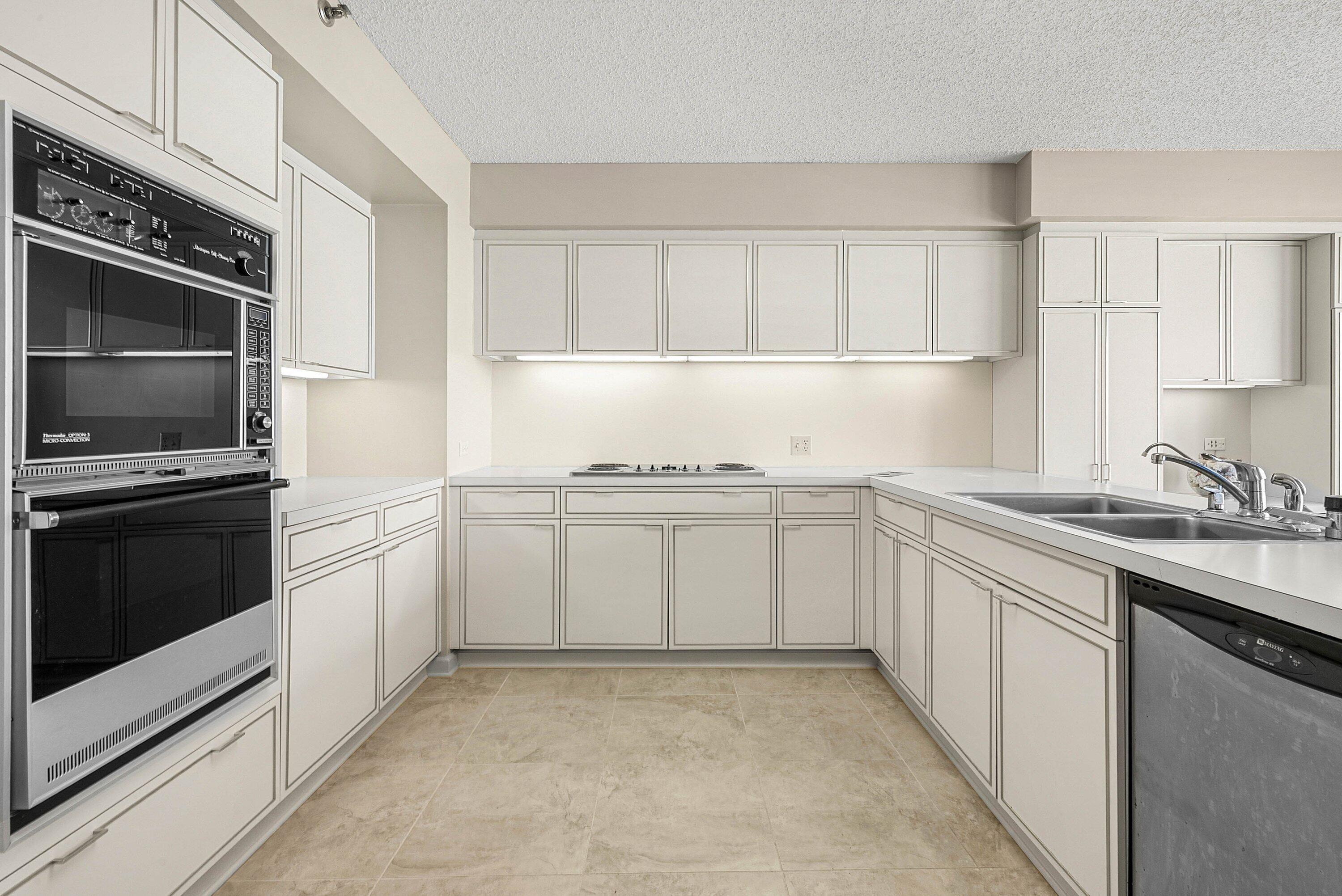 1500 South Ocean Boulevard, Unit 604 Boca Raton, FL 33432 - Photo 18 of 61 a kitchen with white cabinets and appliances