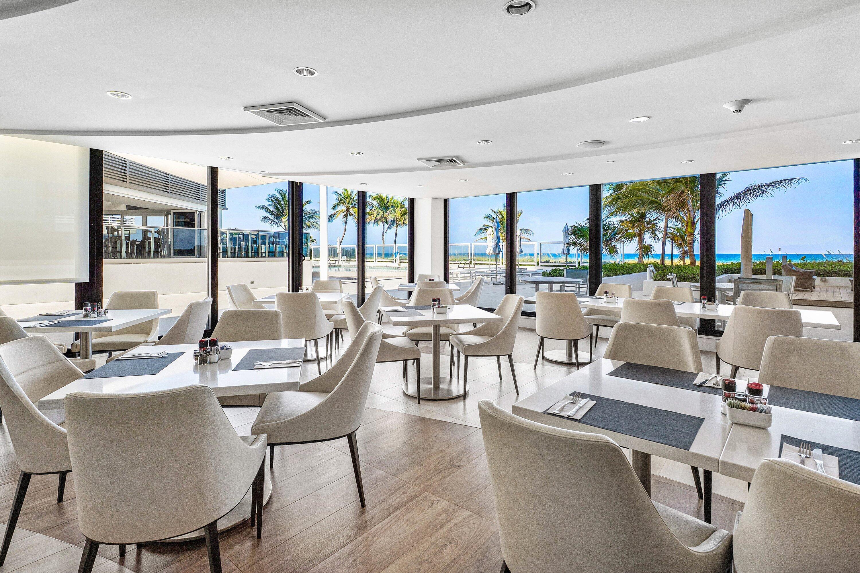 1500 South Ocean Boulevard, Unit 604 Boca Raton, FL 33432 - Photo 39 of 61 a dining room with furniture a large window and a chandelier