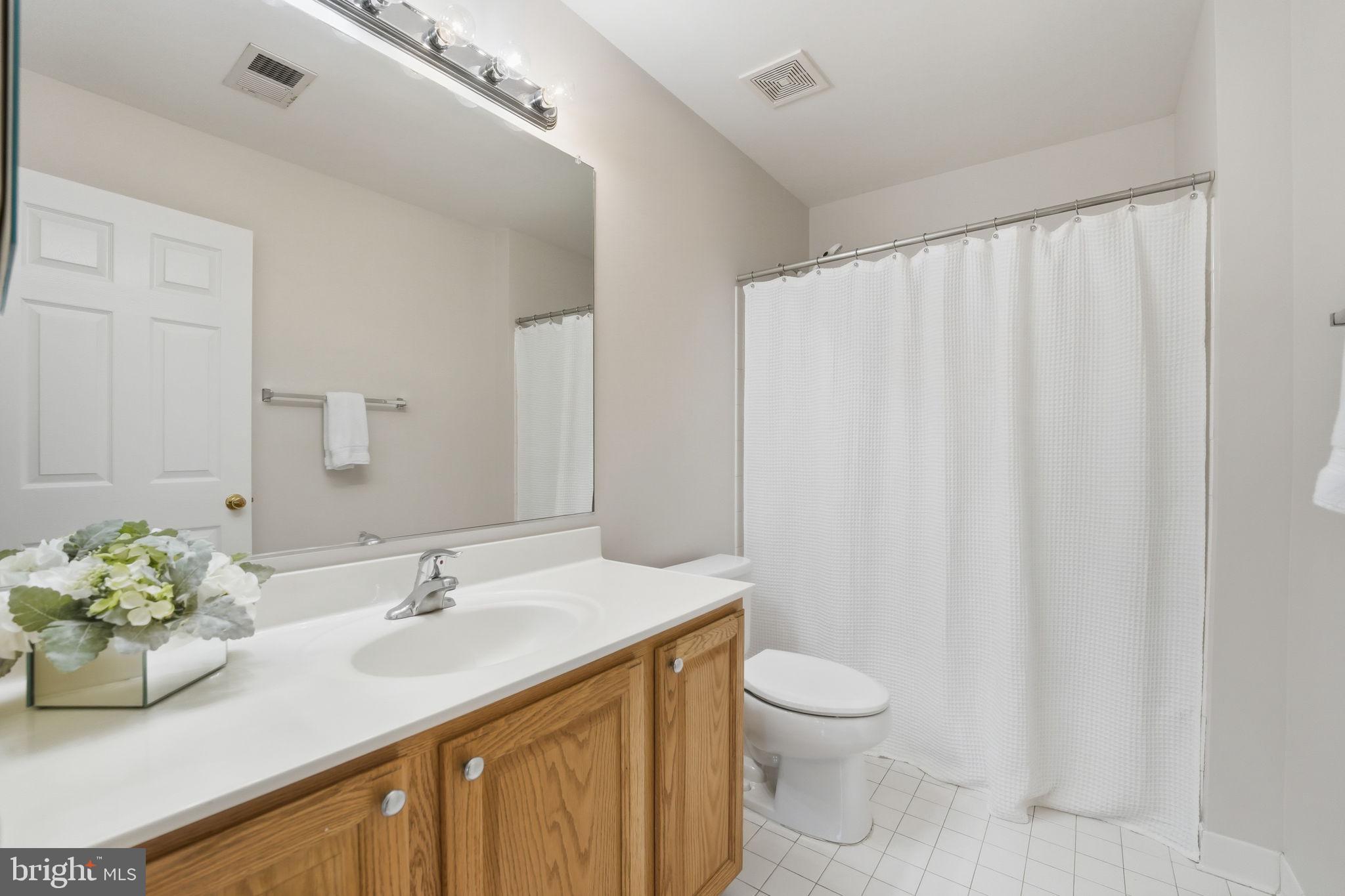 21507 Tithables Circle Broadlands, VA 20148 - Photo 31 of 64 a bathroom with a granite countertop sink toilet and a mirror