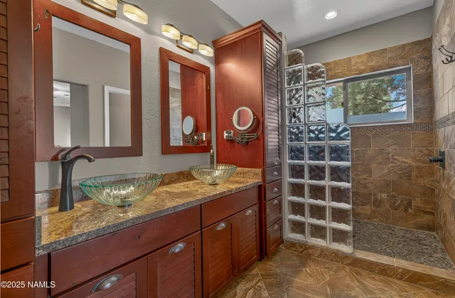 a bathroom with a granite countertop sink a mirror and shower