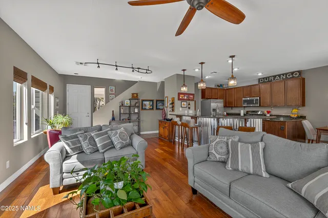 a living room with furniture kitchen view and a large window