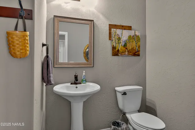 a bathroom with a toilet sink and mirror
