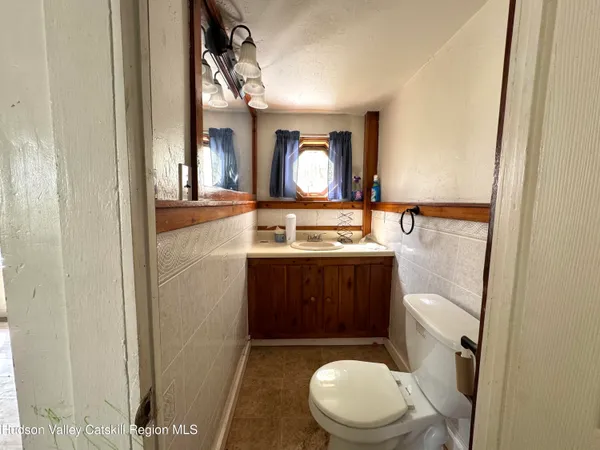 a bathroom with a toilet mirror vanity and a sink