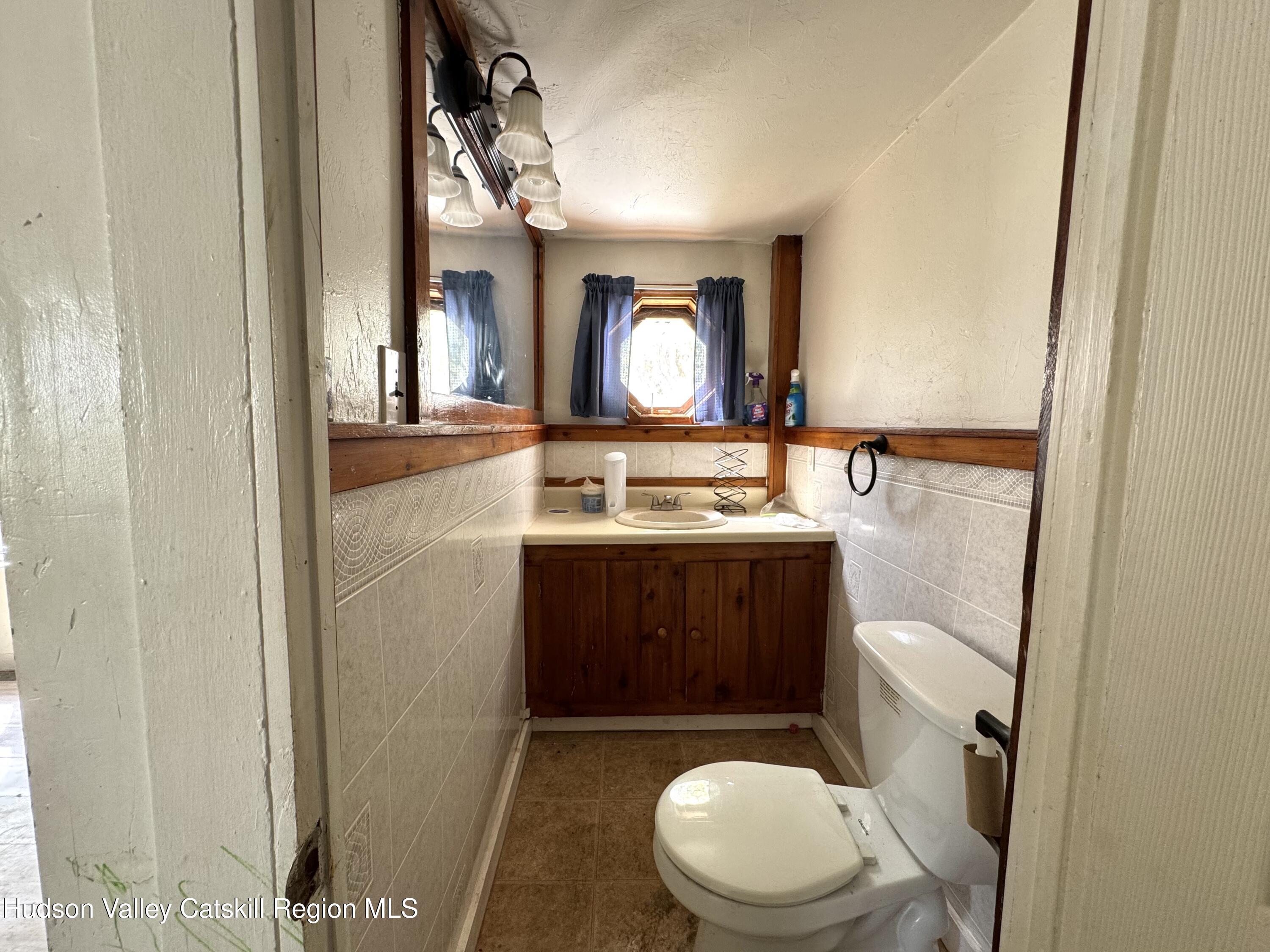 384 Highway 296 Windham, NY 12439 - Photo 26 of 26 a bathroom with a toilet mirror vanity and a sink