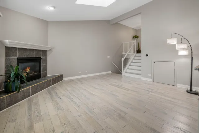 a view of empty room with wooden floor and fireplace