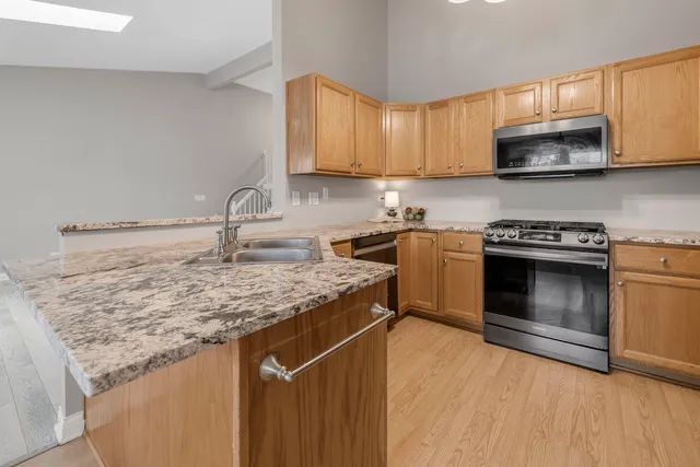 a kitchen with stainless steel appliances granite countertop a sink stove and microwave
