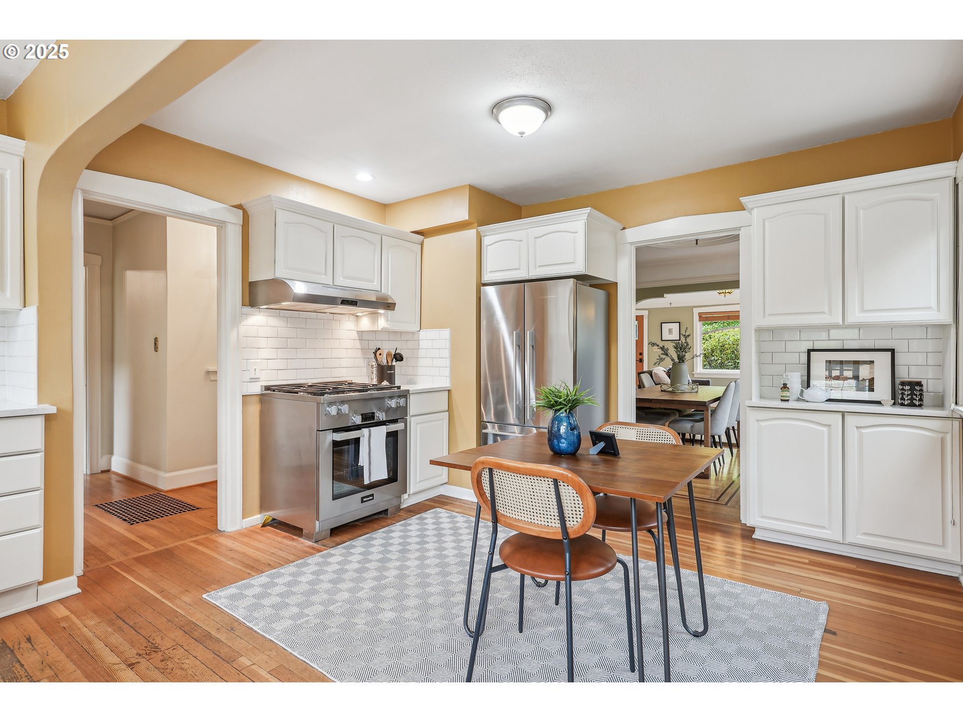 4324 Southeast 28th Avenue Portland, OR 97202 - Photo 15 of 42 a kitchen with stainless steel appliances kitchen island granite countertop a dining table chairs and a refrigerator
