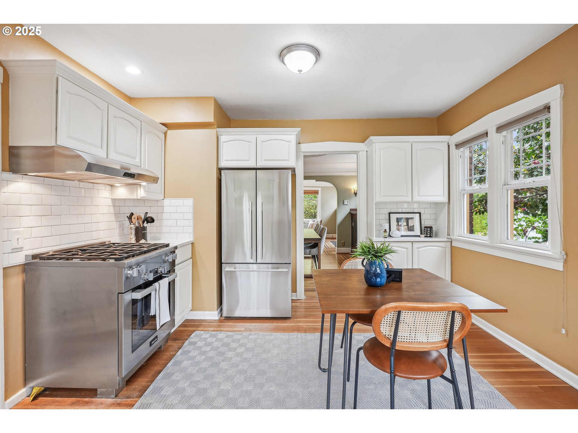 4324 Southeast 28th Avenue Portland, OR 97202 - Photo 17 of 42 a kitchen with stainless steel appliances granite countertop a stove top oven a refrigerator a dining table and chairs with wooden floor
