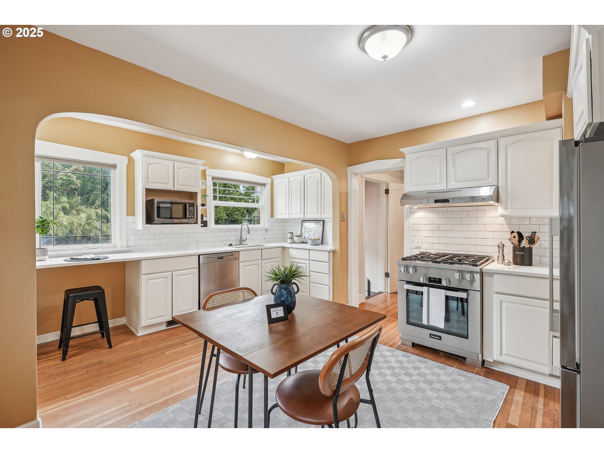 4324 Southeast 28th Avenue Portland, OR 97202 - Photo 18 of 42 a open kitchen with stainless steel appliances granite countertop a stove a refrigerator a kitchen island a stove cabinets a dining table and chairs