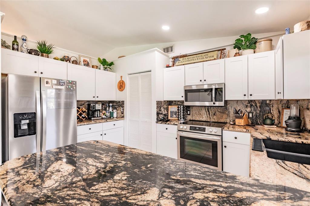 156 Danforth Drive Punta Gorda, FL 33980 - Photo 11 of 58 a kitchen with stainless steel appliances a refrigerator sink stove microwave and cabinets