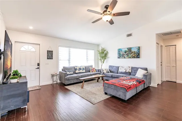 a living room with furniture and a wooden floor